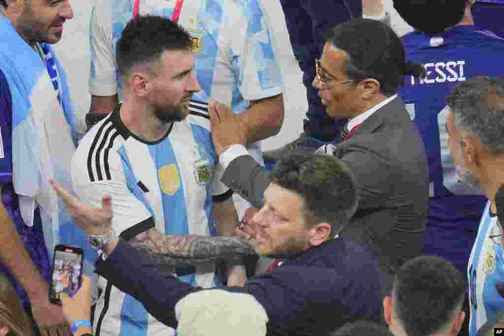 Nusret Gokce, à direita, coloca a sua mão no ombro de Messi, após entrar em campo para festejar com a equipa argentina a vitória do Mundial. Lusail Stadium, Qatar, Dez. 18, 2022.