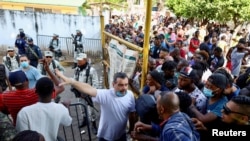 A worker gestures as he talks to migrants who want to regularize their migratory situation outside Mexico's Commission for Refugee Assistance in Tapachula, Chiapas state, Mexico, Jan. 3, 2023.