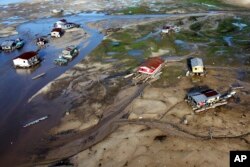 Houseboats sit on land affected by drought near the Solimoes River, in Tefe, Amazonas state, Brazil, on Oct. 19, 2022.