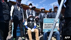 South Korean truck drivers who are on strike have a meeting outside a container port in Incheon, June 14, 2022, on the eighth day of protests over rising fuel costs that have further snarled global supply chains.