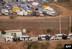 FILE - Paramilitaries of the Moroccan Auxiliary Forces stand guard by the border fence separating Morocco from Spain's North African Melilla enclave after an attempted assault of migrants near Nador, March 4, 2022.