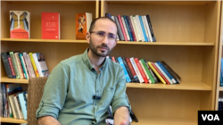 Associate Director Carolina Asia Center, Dr. Kevin W. Fogg, duduk di depan rak buku-buku bertemakan Asia di Fedex Global Education Center UNC Chapel Hill (Foto: VOA).
