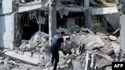 A rescuer walks among ruins of a school in Kharkiv, partially destroyed by a rocket on June 2, 2022 as Russian forces are solidifying their hold on the eastern Donbas region.