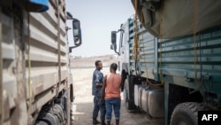 FILE - A member of the Ethiopia Federal Police inspect the cab of a truck at a security checkpoint where a truck aid convoy directed to Ethiopia's Tigray region is being inspected on the outskirts of Semera, Afar region, Ethiopia, May 15, 2022.