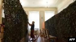 Volunteers weave camouflage nets for Ukrainian military at a library in the western Ukrainian city of Lviv on June 9, 2022. 