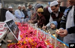 FILE - Indian Muslims pay tribute to Indian soldiers killed in a Pathankot airbase attack, outside a mosque in New Delhi, India, Jan. 8, 2016.