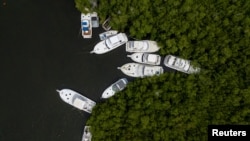 Boats sit secured to mangroves as tropical storm Fiona approaches in Cabo Rojo, Puerto Rico, Sept. 17, 2022. 