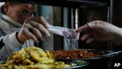 FILE - A man buys food at a restaurant in Cairo, March 22, 2022. 
