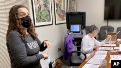 La funcionaria electoral del condado de Dane Rachel Rodriguez (izquierda) supervisa las pruebas de boletas antes de que sean enviadas a más de 200 sitios de votación en el segundo mayor condado de Wisconsin, el 14 de septiembre de 2022. (AP Foto/Scott Bauer)