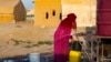 Seorang perempuan Suriah mengisi tangki air di kamp pengungsi Sahlah al-Banat, di Raqa, Suriah utara, pada 19 September 2022. WHO menyebutkan bahwa terdapat resiko tinggi penyebaran wabah kolera di Suriah. (Foto: AFP/Delil Souleiman)