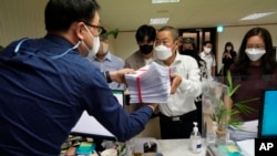 Peter Møller, center, attorney and co-founder of the Danish Korean Rights Group, submits the documents at the Truth and Reconciliation Commission in Seoul, South Korea, Tuesday, Sept. 13, 2022. (AP Photo/Ahn Young-joon)