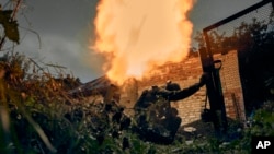 Ukrainian soldiers fire in the recently retaken Kupiansk in the Kharkiv region, Ukraine, Sept. 23, 2022. 