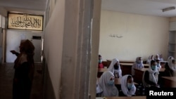 FILE - Girls attend a class in Kabul, Oct. 25, 2021. The Taliban movement, which stormed to power after ousting the Western-backed government, has allowed all boys and younger girls back to class, but has not let girls attend secondary school. 