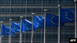 FILE - Flags fly outside the European Commission building in Brussels, June 16, 2022.