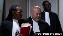 Le procureur général Karim Khan, au centre, entre dans la salle d'audience pour le procès de Mahamat Said Abdel Kani à la Cour pénale internationale de La Haye, aux Pays-Bas, le 26 septembre 2022.