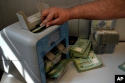Seorang pekerja di biro penukaran uang menghitung pound Lebanon di Beirut, Lebanon, Kamis, 22 September 2022. (AP/Bilal Hussein)