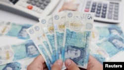 FILE - Woman holds British pound banknotes in this illustration taken May 30, 2022. (Reuters/Dado Ruvic/Illustration)