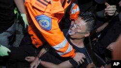 A medical staffer helps a detained man, who protesters claimed was a police officer from mainland China, during a demonstration at the Airport in Hong Kong, Aug. 13, 2019. 