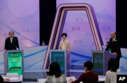 Hong Kong chief executive candidates, former Chief Secretary Carrie Lam, center, former Financial Secretary John Tsang Chun-wah, left, and former judge Woo Kwok-hing attend a chief executive election debate in Hong Kong, March 14, 2017.