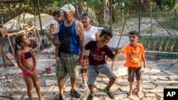 FILE - Gustavo Pijuan and his wife, Sura Victorero, are pictured with their grandchildren at their home in Minas, Cuba, April 29, 2022. Cuba's new Families Code contains an extension of rights of grandparents.