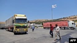 FILE - A convoy transporting humanitarian aid crosses into Syria from Turkey through the Bab al-Hawa border crossing on July 8, 2022. 