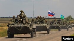 An armored convoy of Russian troops moves through a Russian-held part of Zaporizhzhia region, Ukraine, July 23, 2022. 