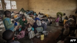 FILE - Internally displaced children, fleeing clashes between M23 rebels and Congolese soldiers, eat a meal prepared by volunteers in Kanyarushinya, north of Goma, May 27, 2022.