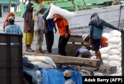 Pekerja memuat karung pupuk di sebuah pelabuhan di Jakarta, 7 Desember 2007. (Foto: AFP/Adek Berry)
