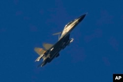 FILE - A Chinese J-11 military fighter jet flies above the Taiwan Strait near Pingtan, the closest land of mainland China to the island of Taiwan, in Pingtan in southeastern China's Fujian Province, Aug. 5, 2022.