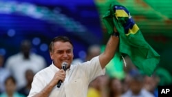 Brazil's President Jair Bolsonaro holds a Brazilian flag during a rally to launch his reelection bid, in Rio de Janeiro, Brazil, July 24, 2022.