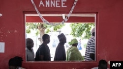 People wait in line outside their voting station in the popular neighborhood of Ngor in Dakar on July 31, 2022, as voting starts in Senegal's legislative elections.