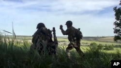 In this handout photo released by Russian Defense Ministry Press Service on July 20, 2022, Russian soldiers fire a mortar from their position at an undisclosed location in Ukraine. 