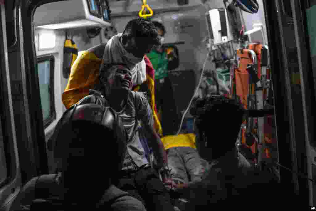 An injured protester reacts in pain in an ambulance as he is taken to a hospital during clashes with police near parliament in Colombo, July 13, 2022.