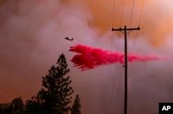A plane drops retardant while battling the Oak Fire in Mariposa County, Calif., July 22, 2022.