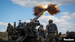 FILE - Ukrainian service members fire a shell from a towed howitzer FH-70 at a front line, as Russia's attack on Ukraine continues, in Donbas Region, Ukraine, July 18, 2022. 