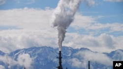 FILE - The Utah State Capitol, rear, is shown behind an oil refinery May 12, 2022, in Salt Lake City.