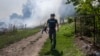 FILE - An AFP journalist runs as smoke rises behind after a bombardment in Bakhmut, Eastern Ukraine, July 31, 2022.