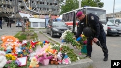A Ukrainian serviceman lays flowers on July 15, 2022, at the site of a Russian shelling in Vinnytsia, Ukraine. Russian missiles struck the central Ukrainian City the previous day, killing at least 23 people and injuring more than 100 others, Ukrainian officials said. 