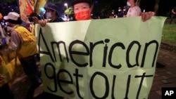 A protester holds a banner during a protest against the visit of United States House Speaker Nancy Pelosi, outside a hotel in Taipei, Taiwan, Aug. 2, 2022.
