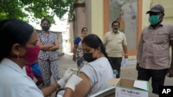 Seorang petugas kesehatan memberikan vaksin COVID-19 jenis Covishield di sebuah lokasi vaksinasi di Hyderabad, India, pada 15 Juli 2022. (Foto: AP/Mahesh Kumar A.)