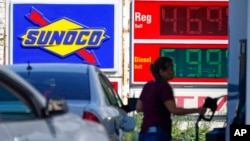 A woman pumps gas at a Sunoco mini-mart in Independence, Ohio, July 12, 2022.