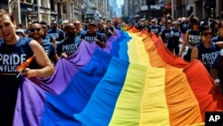 FILE - Reveler carry a LTBGQ flag along Fifth Avenue during the New York City Pride Parade on June 24, 2018.