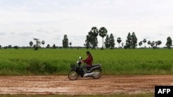 រូបឯកសារ៖ ស្ត្រីម្នាក់ជិះម៉ូតូនៅតាមផ្លូវលំមួយ នៅខេត្តសៀមរាប កាលពីថ្ងៃទី ១៥ ខែតុលា ឆ្នាំ ២០២០។ 