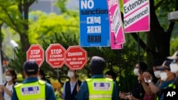 Demonstranti drže transparente protiv sankcija Sjevernoj Koreji, saveza SAD, Južne Koreje i Japana i politike odvraćanja tokom mitinga ispred Ministarstva spoljnih poslova u kojem se sastaju predstavnici SAD, Južne Koreje i Japana, u Seulu, Južna Koreja, 3. juna 2022.