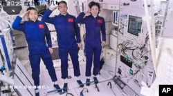 In this screengrab captured at Beijing Aerospace Control Center and released by Xinhua News Agency, Chinese astronauts from left, Liu Yang, Chen Dong and Cai Xuzhe salute after entering the space station core module Tianhe, June 5, 2022.