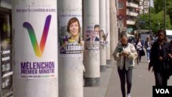 People pass campaign posters for far-left candidate Sarah Legrain and Jean-Luc Melenchon, leader of the France Unbowed party, who wants to become France's next prime minister. (Lisa Bryant/VOA)