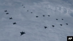 In this photo provided by South Korea Defense Ministry, US and South Korean fighter jets fly in formation during a joint drill, June, 7, 2022.