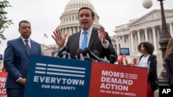FILE - Democratic Senator Chris Murphy is joined at left by Senator Alex Padilla, also a Democrat, as they speak to activists demanding action on gun control legislation, at the Capitol, in Washington, May 26, 2022. 