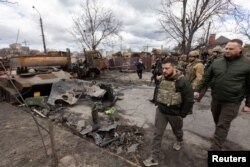 Presiden Ukraina Volodymyr Zelenskiy berjalan di samping kendaraan militer Rusia yang hancur, saat serangan Rusia ke Ukraina berlanjut, di kota Bucha, di luar Kyiv, Ukraina 4 April 2022. (Foto: via Reuters)
