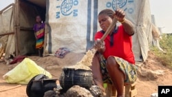 FILE - Mtonga Iliamgee, an internally displaced person at the Guma IDPs camp, prepares flour as the first meal for her family inside the camp in Benue State in north central Nigeria, Jan 6, 2022.